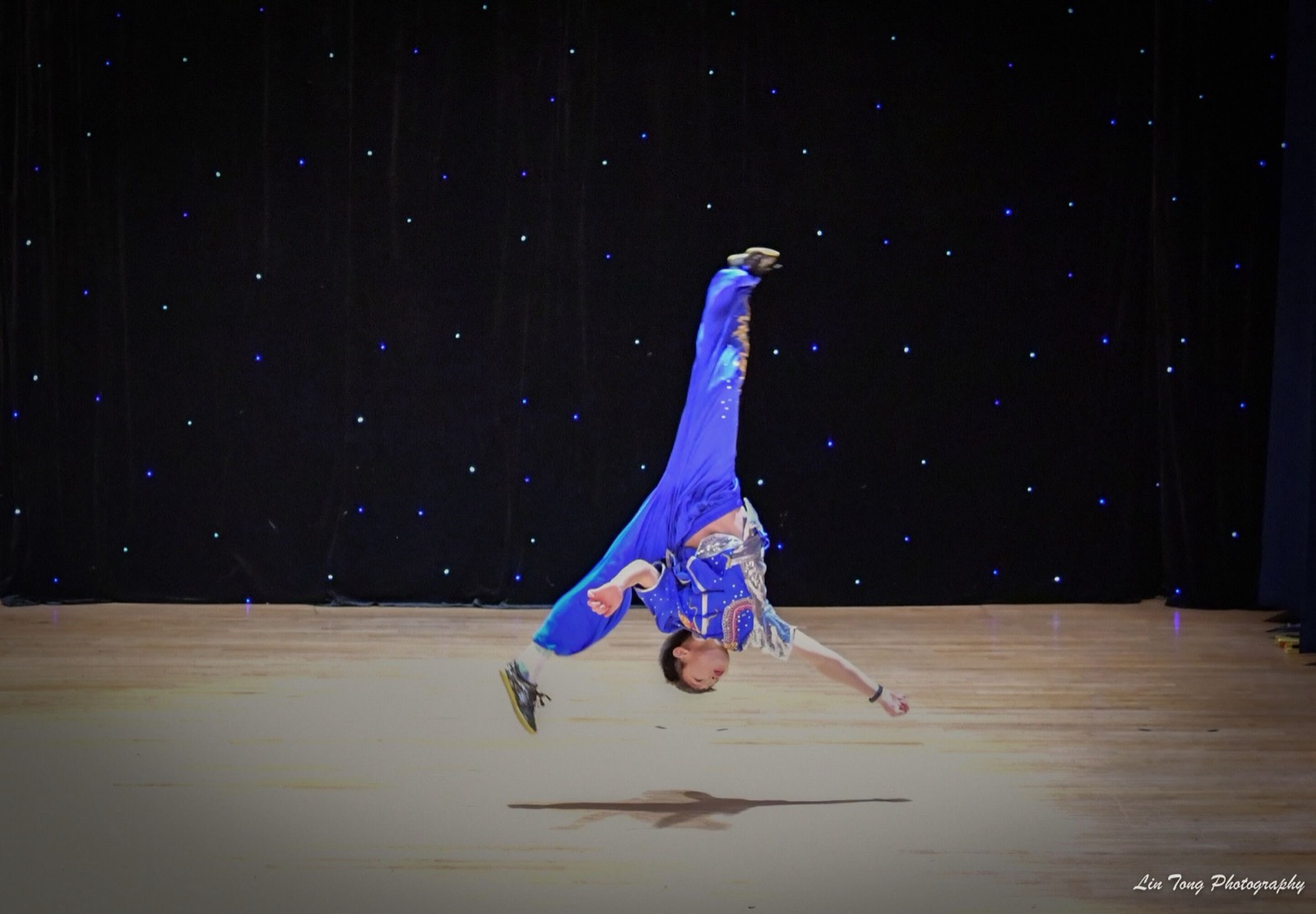 A student mid-aerial on stage