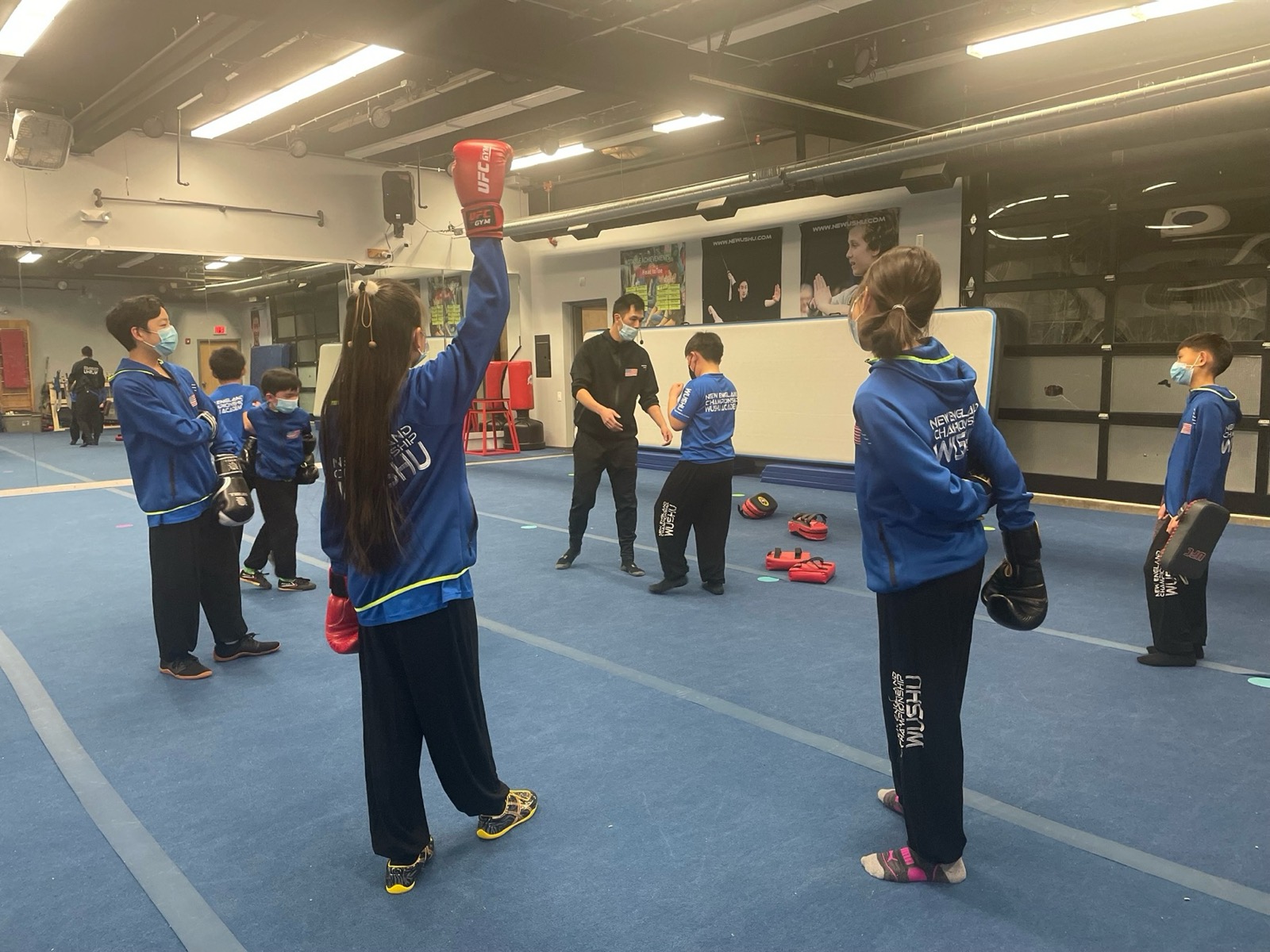 A sanda class works on pads with a coach